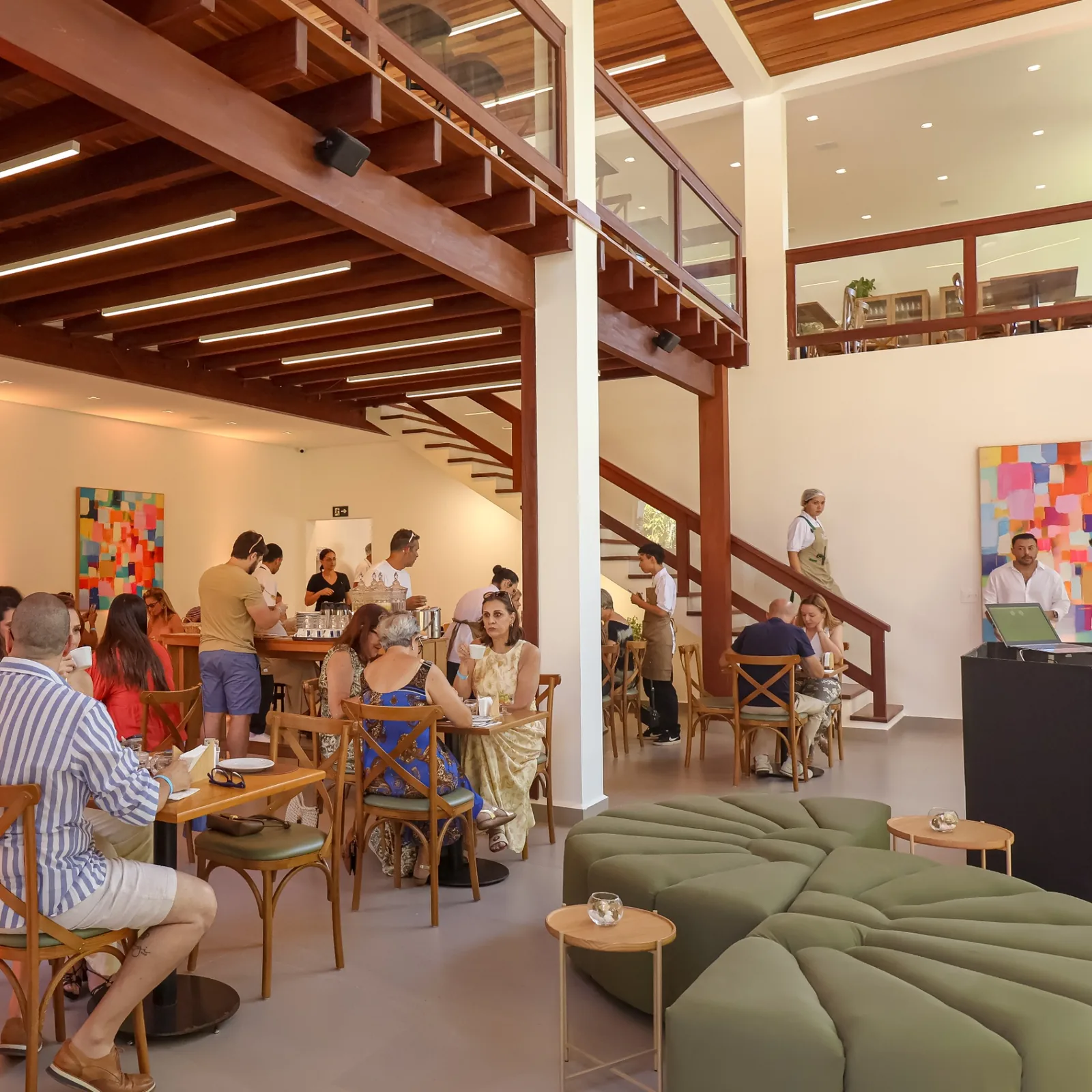 Salão principal do Frutta e Crema Lounge com pé-direito duplo e mezanino em madeira